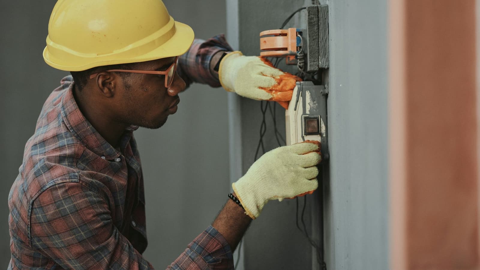 A maintenance technician servicing a building control panel during a planned FM visit.