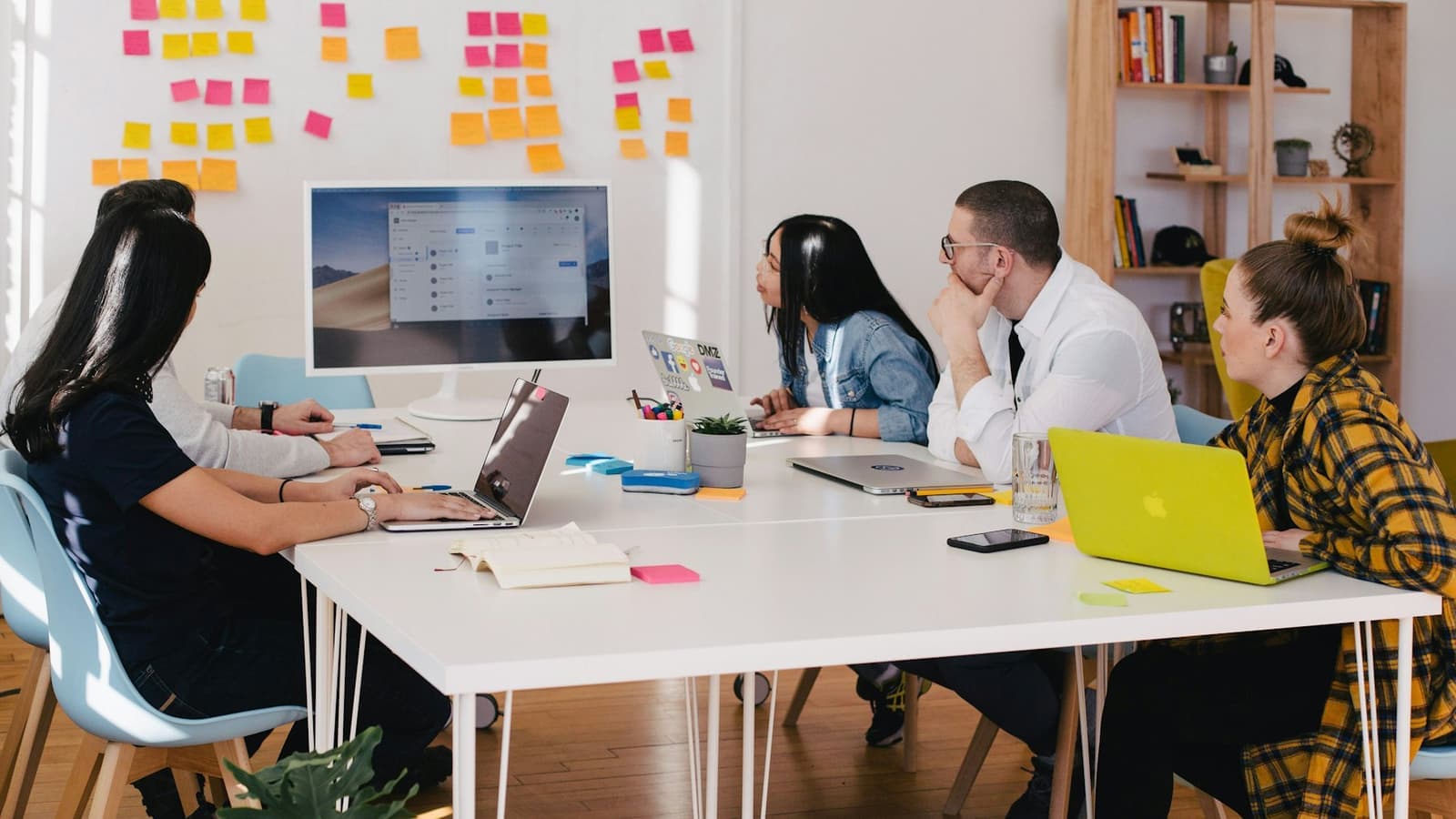 An outsourced back-office team working together at a shared desk in the AW Realtors operations hub.